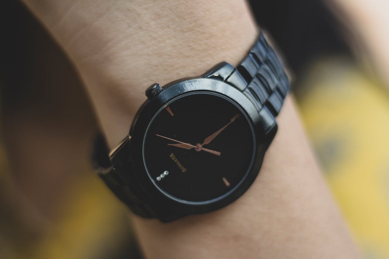 Detailed close-up of a sleek black analog wristwatch focusing on its design and sophistication.