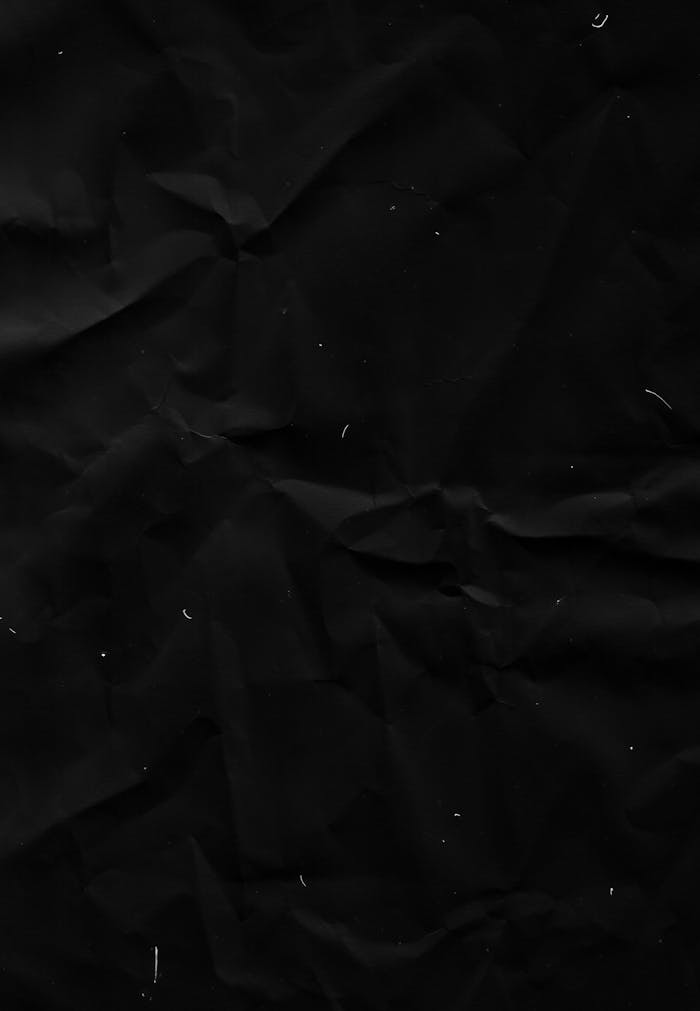 High contrast image of crumpled black paper, perfect for backgrounds or textures.