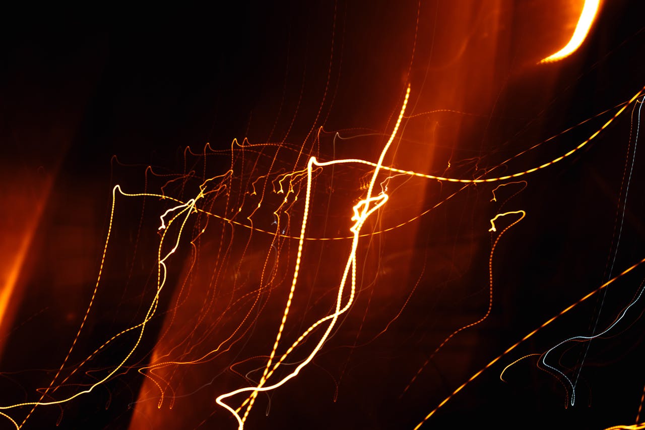 Dynamic abstract image with orange and yellow light streaks creating a vibrant motion effect.